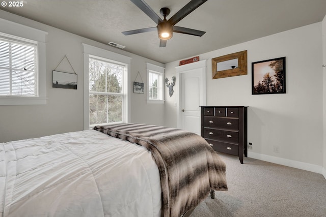 carpeted bedroom featuring visible vents, baseboards, and ceiling fan