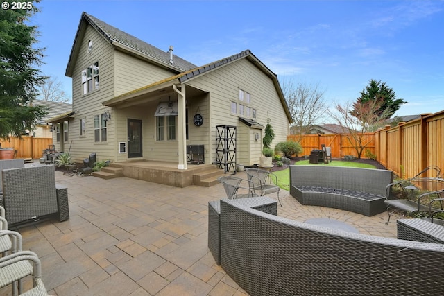 rear view of house with an outdoor hangout area, a fenced backyard, and a patio area