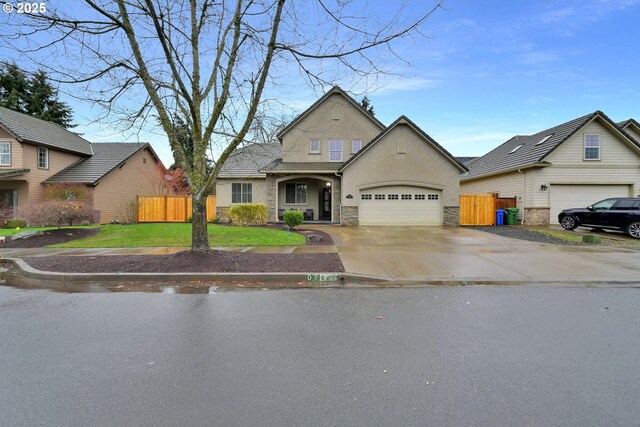 traditional-style house with stucco siding, driveway, stone siding, fence, and a garage