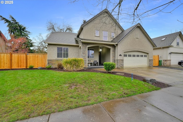 view of front of home featuring stucco siding, stone siding, fence, a front yard, and a garage