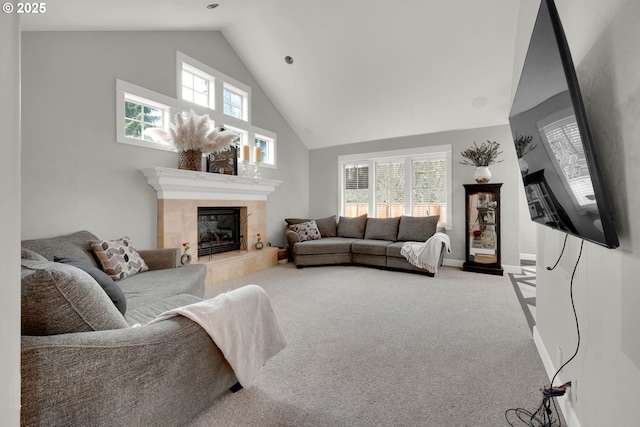 living room featuring baseboards, a tile fireplace, carpet floors, and high vaulted ceiling