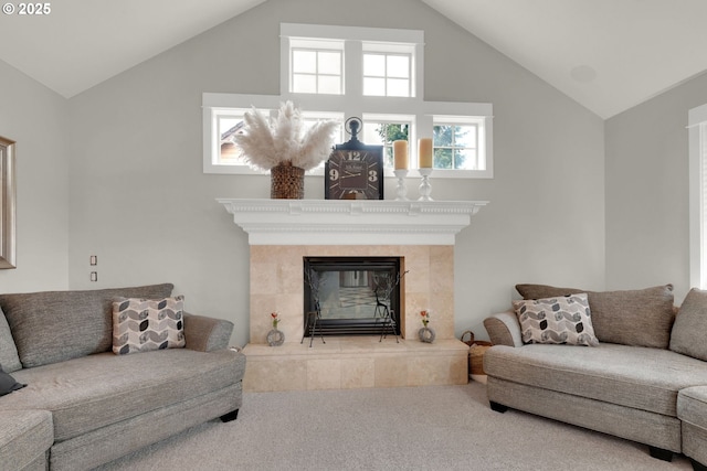 living area with carpet, vaulted ceiling, and a tile fireplace