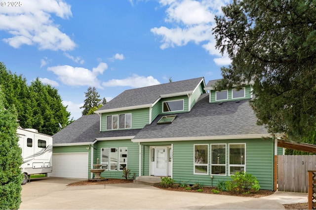 view of front facade featuring a shingled roof, driveway, fence, and an attached garage