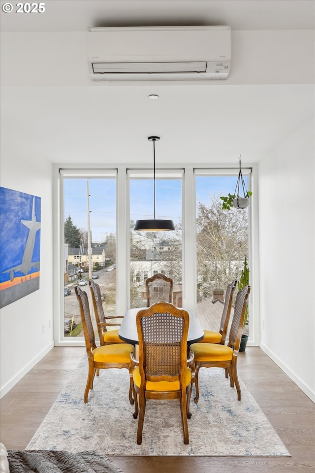 1375 N Wygant St, Portland, OR 97217 - dining area featuring a wall mounted AC, wood finished floors, and baseboards