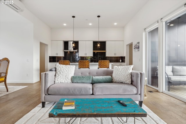 1375 N Wygant St, Portland, OR 97217 - living room featuring light wood-style flooring, an AC wall unit, recessed lighting, and baseboards