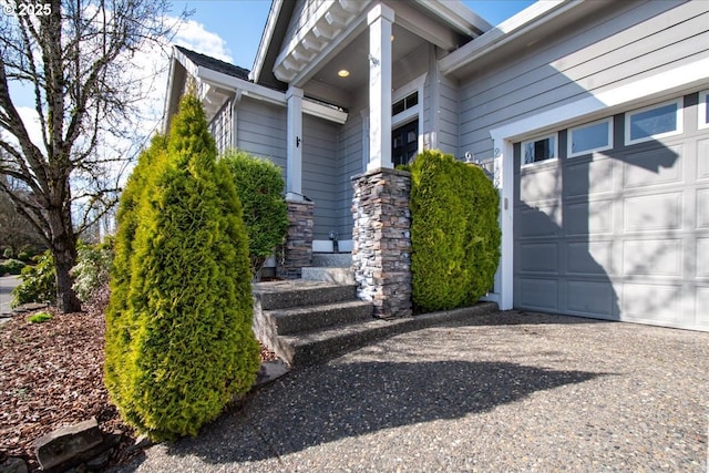 doorway to property with a garage and driveway