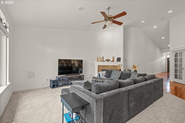 carpeted living room featuring high vaulted ceiling, a ceiling fan, recessed lighting, a fireplace, and baseboards