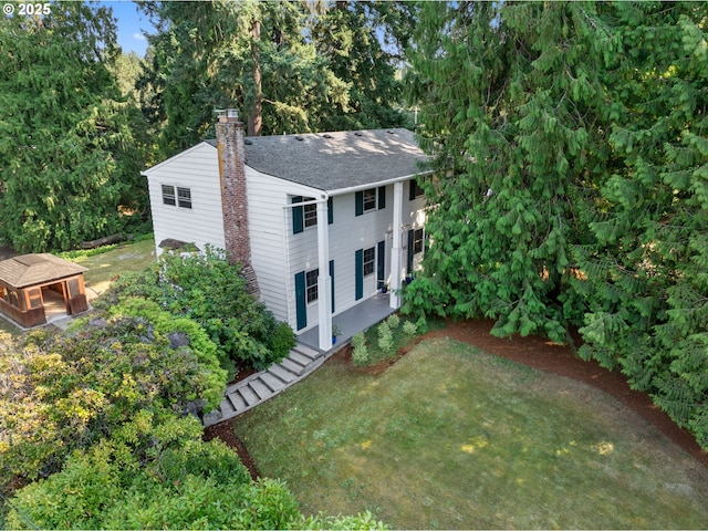 view of front of property featuring an outbuilding, a chimney, and a front lawn