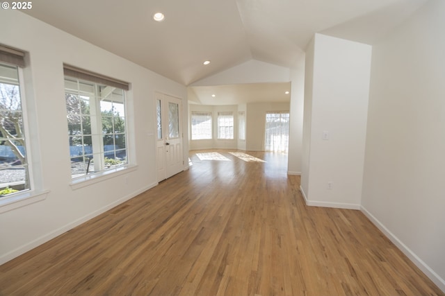 unfurnished room featuring vaulted ceiling and light wood-type flooring