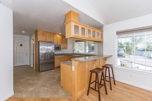 1985 32nd St, Florence, OR 97439 - kitchen featuring glass insert cabinets, a kitchen breakfast bar, a peninsula, stainless steel appliances, and baseboards