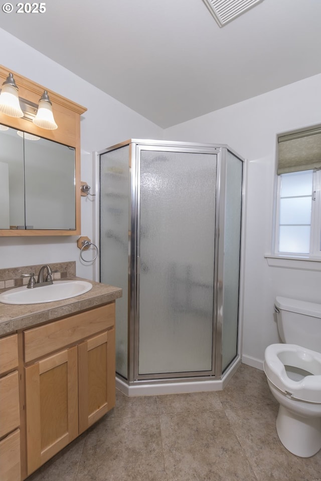 bathroom with vanity, a shower with shower door, tile patterned floors, and toilet