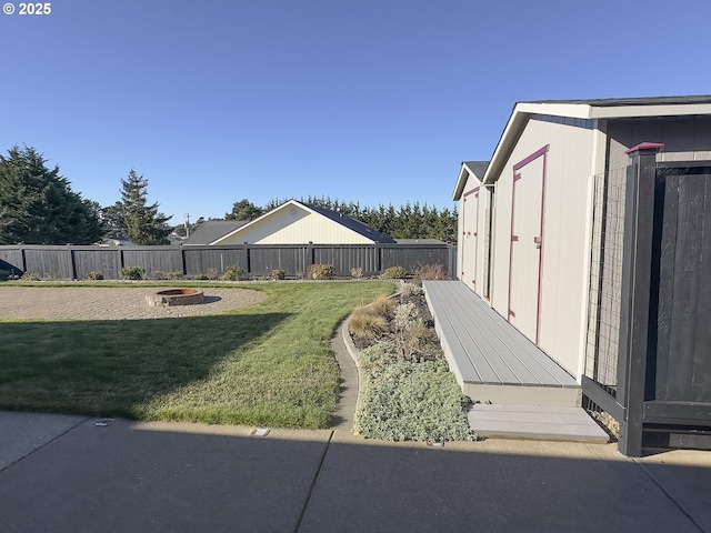 view of yard featuring a storage shed and a fire pit