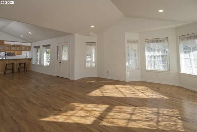 1985 32nd St, Florence, OR 97439 - unfurnished living room featuring wood finished floors, baseboards, and vaulted ceiling
