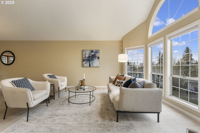 living area featuring baseboards, carpet floors, and high vaulted ceiling