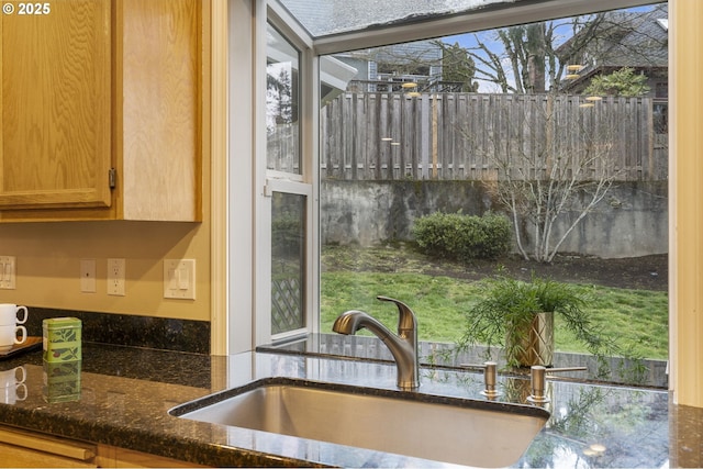 kitchen with a sink and dark stone counters