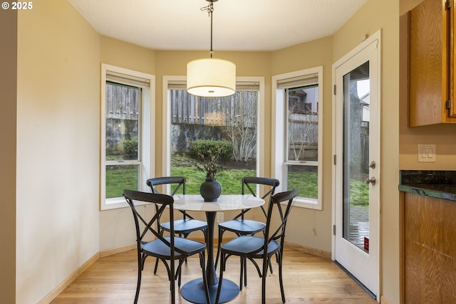 dining space featuring baseboards and light wood-style floors