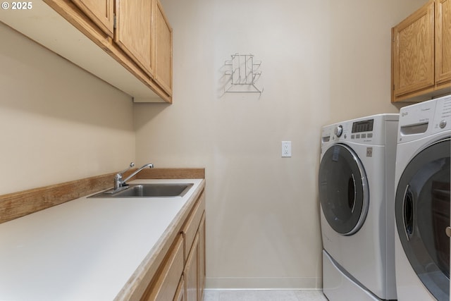 laundry area with a sink, baseboards, cabinet space, and independent washer and dryer