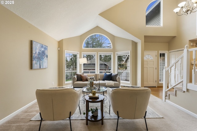 living room with baseboards, high vaulted ceiling, stairs, a notable chandelier, and light colored carpet