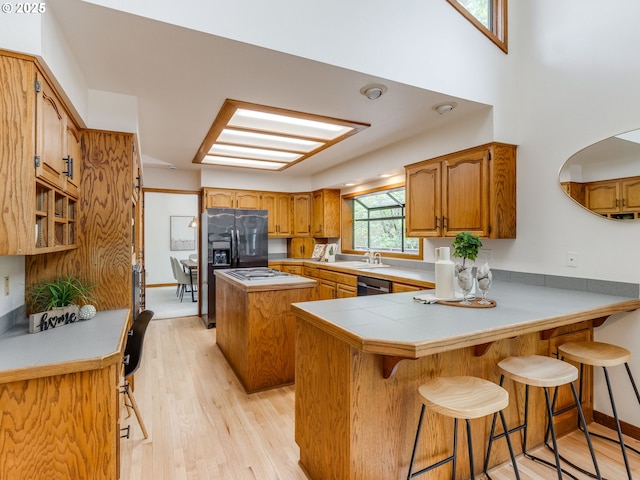 2972 Tolkien Ln, Lake Oswego, OR 97034 - kitchen featuring a peninsula, stainless steel dishwasher, light wood-style floors, brown cabinetry, and a sink