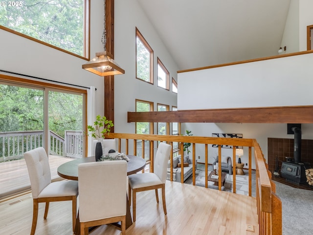 2972 Tolkien Ln, Lake Oswego, OR 97034 - dining area featuring high vaulted ceiling, a wood stove, and wood finished floors
