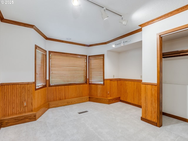 2972 Tolkien Ln, Lake Oswego, OR 97034 - spare room featuring rail lighting, a wainscoted wall, wooden walls, crown molding, and light carpet