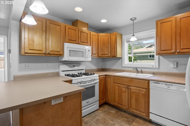 kitchen featuring a sink, white appliances, light countertops, a peninsula, and pendant lighting