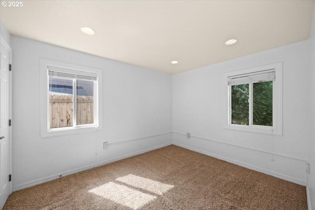 carpeted empty room featuring recessed lighting, baseboards, and a wealth of natural light