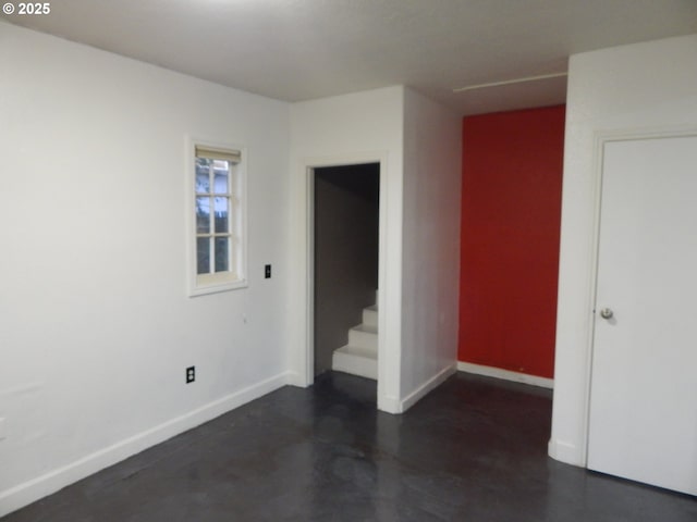 325 River Rd, Eugene, OR 97404 - spare room with baseboards, stairs, and finished concrete floors