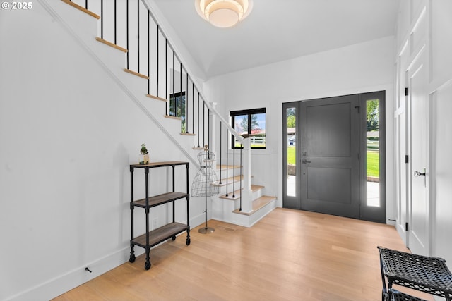 entrance foyer featuring wood finished floors, stairway, and baseboards