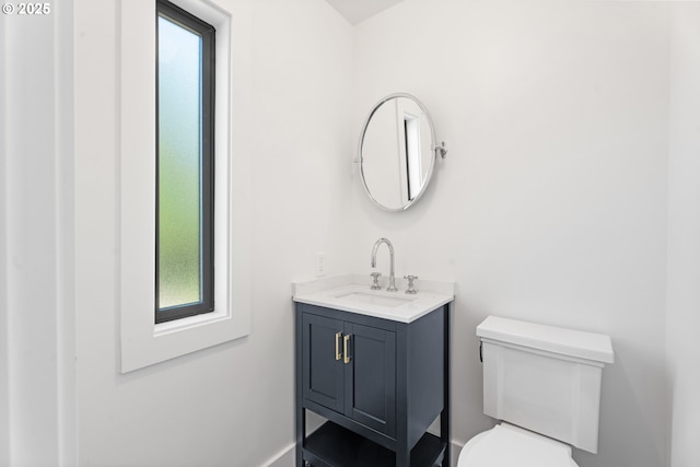 bathroom with toilet, vanity, and healthy amount of natural light