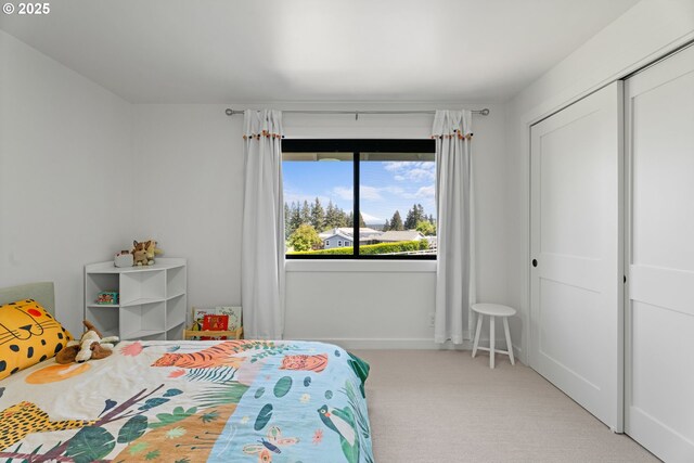 carpeted bedroom with a closet and baseboards