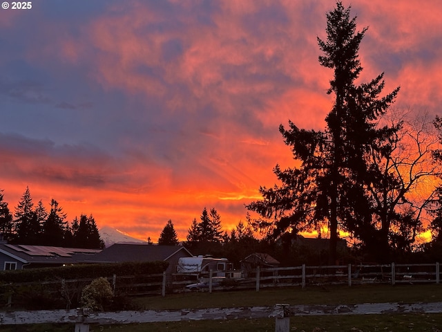 yard at dusk featuring fence