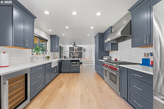 kitchen featuring beverage cooler, stainless steel appliances, a sink, tasteful backsplash, and recessed lighting