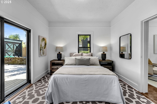6206 N Denver Ave, Portland, OR 97217 - bedroom with baseboards, access to exterior, a textured ceiling, and wood finished floors