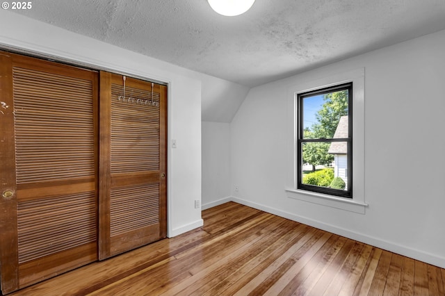 6206 N Denver Ave, Portland, OR 97217 - bonus room with baseboards, hardwood / wood-style floors, a textured ceiling, and vaulted ceiling