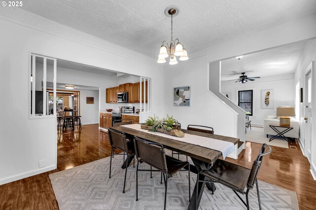 6206 N Denver Ave, Portland, OR 97217 - dining area with a chandelier, wood finished floors, a textured ceiling, baseboards, and ceiling fan