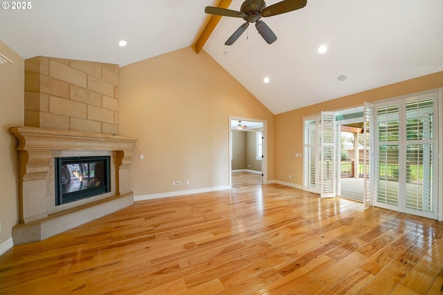 unfurnished living room with high vaulted ceiling, a fireplace, ceiling fan, beam ceiling, and light hardwood / wood-style flooring