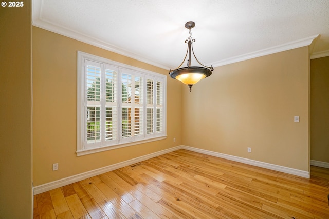 empty room with ornamental molding and light hardwood / wood-style floors