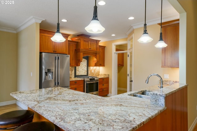 kitchen featuring appliances with stainless steel finishes, sink, pendant lighting, and kitchen peninsula