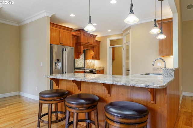 kitchen with sink, light wood-type flooring, ornamental molding, kitchen peninsula, and backsplash