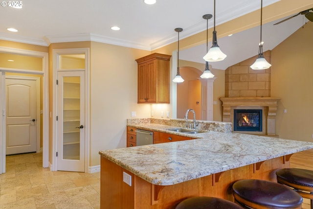 kitchen featuring pendant lighting, sink, stainless steel dishwasher, light stone counters, and kitchen peninsula