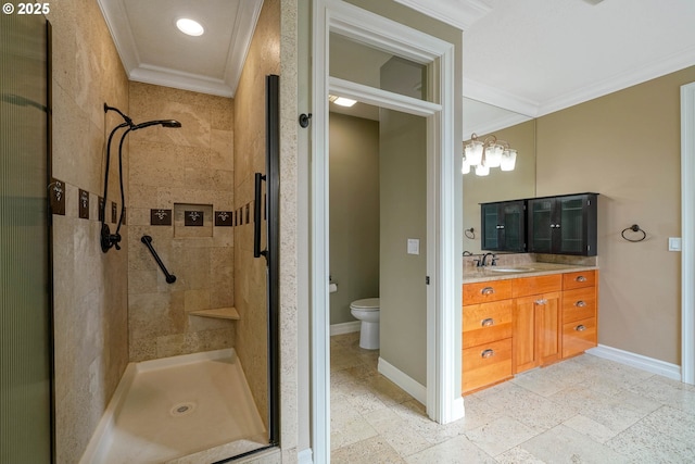 bathroom with ornamental molding, a tile shower, vanity, and toilet