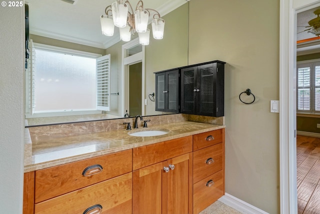 bathroom with vanity, crown molding, and a chandelier