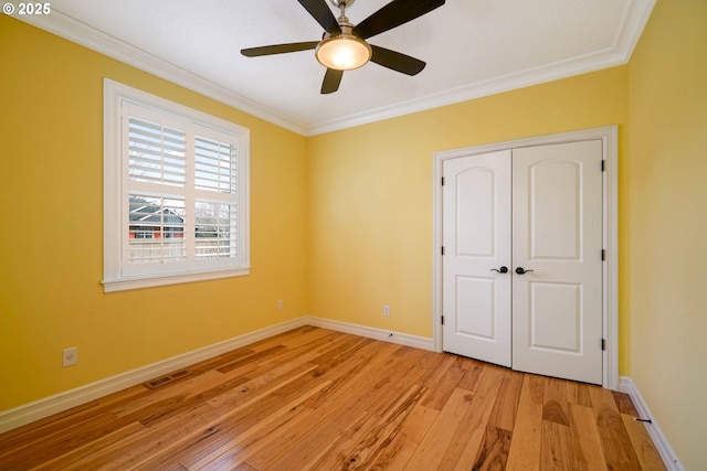 unfurnished bedroom featuring crown molding, light hardwood / wood-style floors, a closet, and ceiling fan