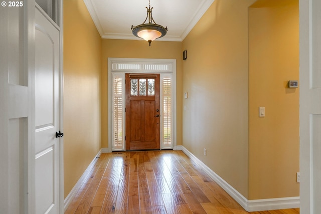 foyer entrance featuring crown molding and light hardwood / wood-style floors