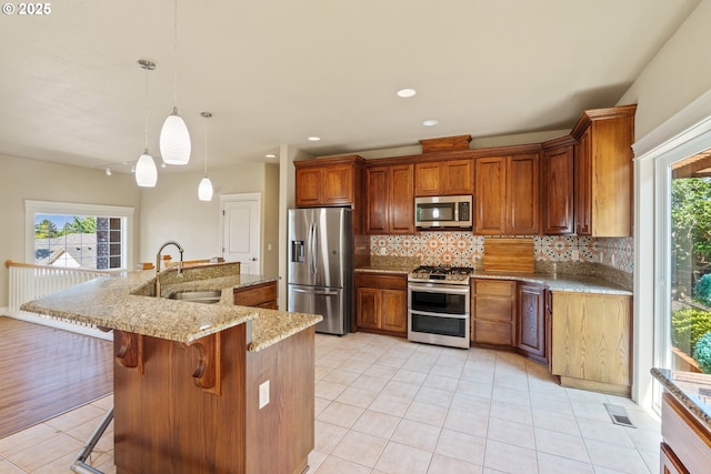 1748 Hardin Ave NW, Salem, OR 97304 - kitchen with stainless steel appliances, a sink, light tile patterned floors, tasteful backsplash, and brown cabinetry
