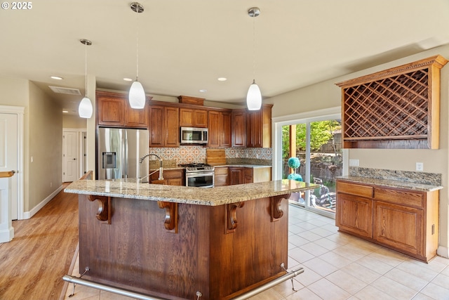 1748 Hardin Ave NW, Salem, OR 97304 - kitchen featuring appliances with stainless steel finishes, backsplash, a kitchen bar, light stone countertops, and a sink