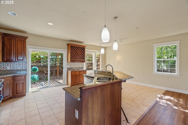 1748 Hardin Ave NW, Salem, OR 97304 - kitchen featuring a sink, light tile patterned floors, a kitchen breakfast bar, and a center island with sink