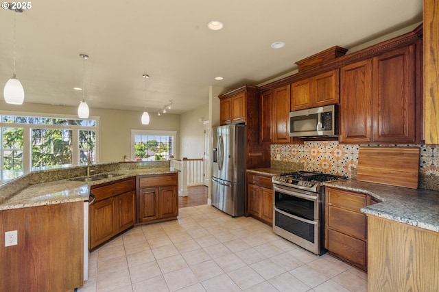 1748 Hardin Ave NW, Salem, OR 97304 - kitchen with stainless steel appliances, light tile patterned flooring, decorative backsplash, a sink, and decorative light fixtures