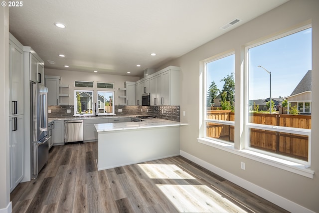 24934 Westfield Ave, Veneta, OR 97487 - kitchen with appliances with stainless steel finishes, open shelves, a peninsula, backsplash, and wood finished floors
